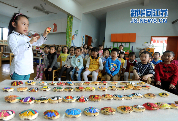 10月22日，苏州市平江实验幼儿园的几名小朋友在展示各自参展的蟹壳“脸谱”作品(杭兴微 摄)